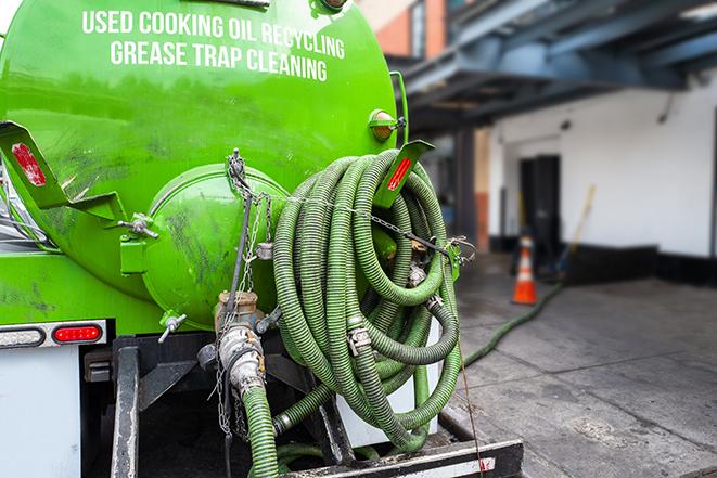 a grease trap being pumped by a sanitation technician in Independence MI